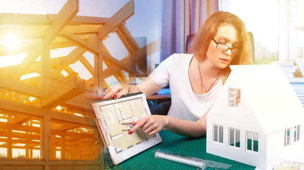 Architect. The frame of the building. Woman with a floor plan. Architect working on a wireframe plan. Concept - house design. Career at the architectural bureau. Architect examines house layout