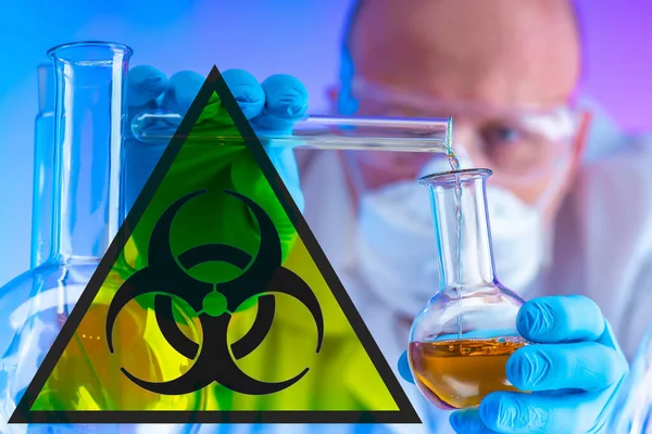 Biohazard. A man mixes chemical liquids in test tubes. Biohazard sign on the lab. Experiments with dangerous substances are conducted in the laboratory.
