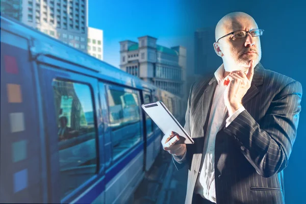 A man with an electronic tablet in his hands against the background of the city. Use of electronic cards. Planning your trip route. The man chooses the most convenient route.