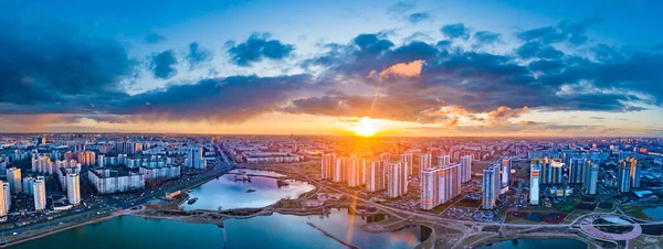 Aerial photography of the city at sunset. Panorama of the evening city from a drone. Modern urban architecture. Urban landscape at sunset. Residential buildings next to the ponds.