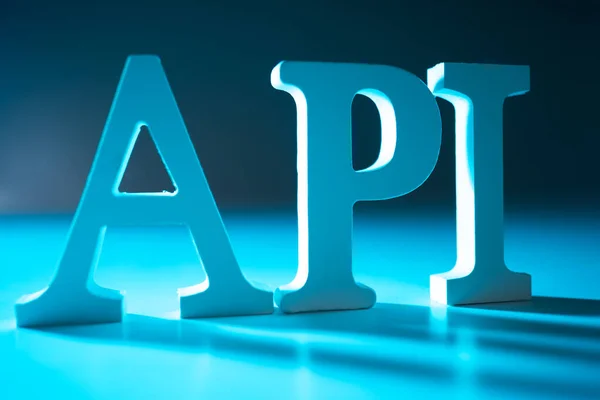 Large API letters on a blue background. Api. Application programming interface. Program interface for interacting with other programs. API technologies in programming.