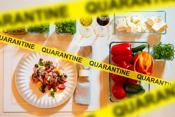 A set table in a restaurant behind a barrier tape with the word Quarantine. Ban on the operation of public catering companies due to coronavirus. Closing cafes and restaurants during the epidemic.