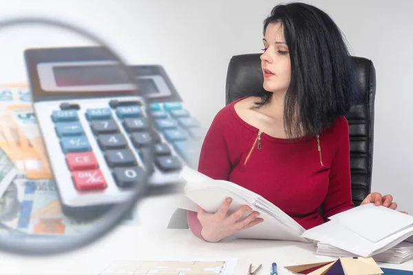 A girl with accounting documents and banknotes on the background of a magnifying glass. The correctness of the accounting. Cash operations. Auditor check. Company finances.