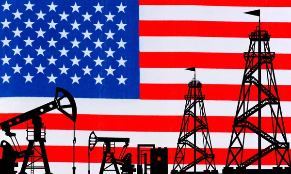 Oil rigs on the background of the American flag. America\'s oil industry. The export of American oil. Global energy market. Natural resource extraction in the United States. Fuel industry of the US.