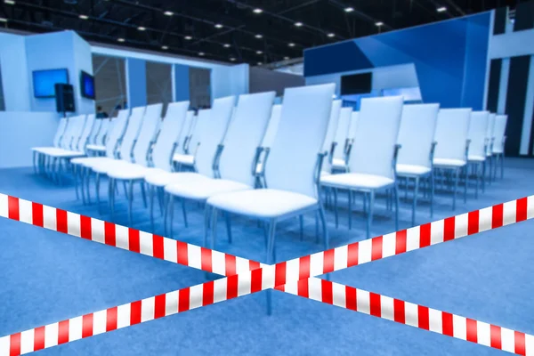 Empty conference room. Concept - event canceled due quarantine. Prohibition tape in hall for events. Concept - conference has been rescheduled. Empty chairs in large room. Place for training is empty