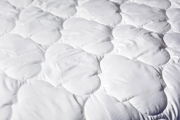 Sleep products. White blanket. Soft feather bed. Mattress for the bed. Soft background made of home textiles. Soft and cozy background.