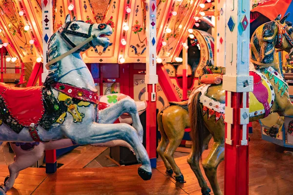 Carousels. Wooden horses spin around the post. Joy for children. Children\'s entertainment. The bright carousels are empty. Carousels are waiting for kids. Riding on wooden horses.