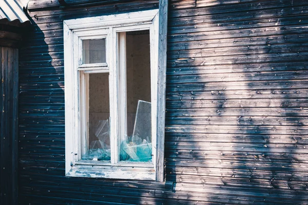 Janelas quebradas de uma velha casa de madeira. — Fotografia de Stock