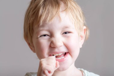 Elinde sarı şeker olan sevimli bir bebek.