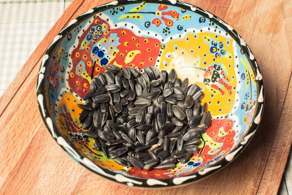Жареные семена в красивой тарелке на деревянной доске . — стоковое фото