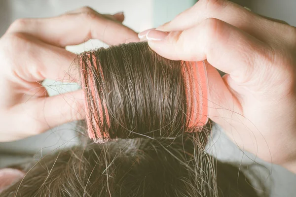 Les filles mains boucler les cheveux sur les bigoudis rouges . — Photo