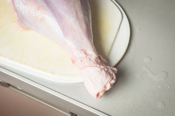 Patas de pavo descongeladas en tabla de cortar blanca para cocinar . — Foto de Stock