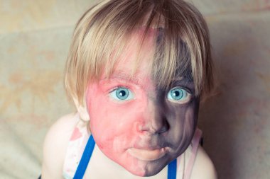 Büyük gözlü ve boyalı yüzlü küçük çocuk