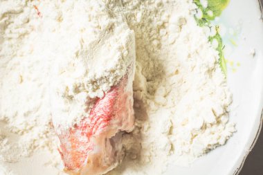 Taze levrek tavada kızartmak için beyaz un haddelenmiş