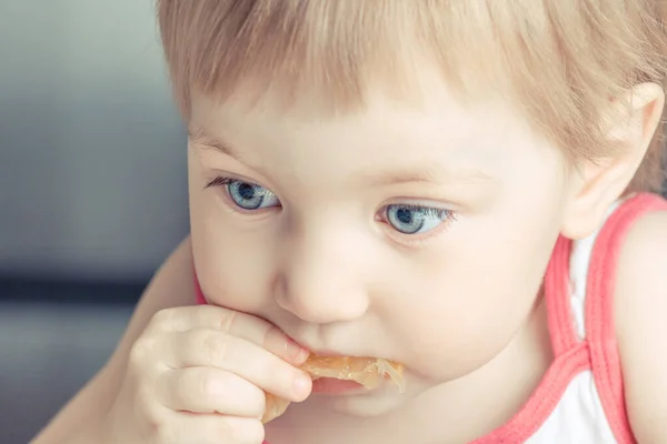 Дитина Великими Блакитними Очима Їсть Апельсиновий Шматочок — стокове фото