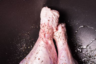 Fırında kızarmak için büyük bir kazanda tuz ve biber serpiştirilmiş çiğ hindi bacakları..