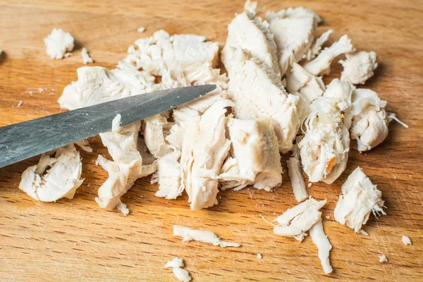 Sliced chicken breast with knife on wooden board. — Stock Photo, Image