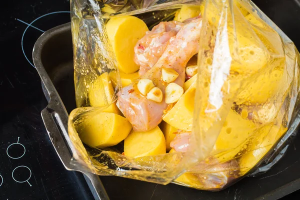 오븐에 구운 봉지에 생 닭 다리와 얇게 썬 감자. — 스톡 사진