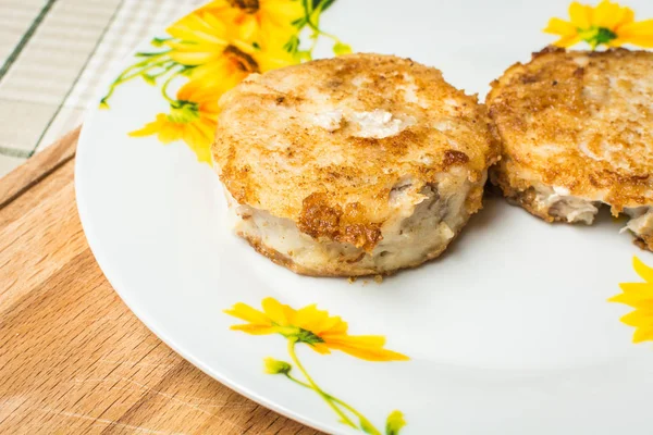 Gebakken ronde heek visfilets in plaat op keuken tafel. — Stockfoto