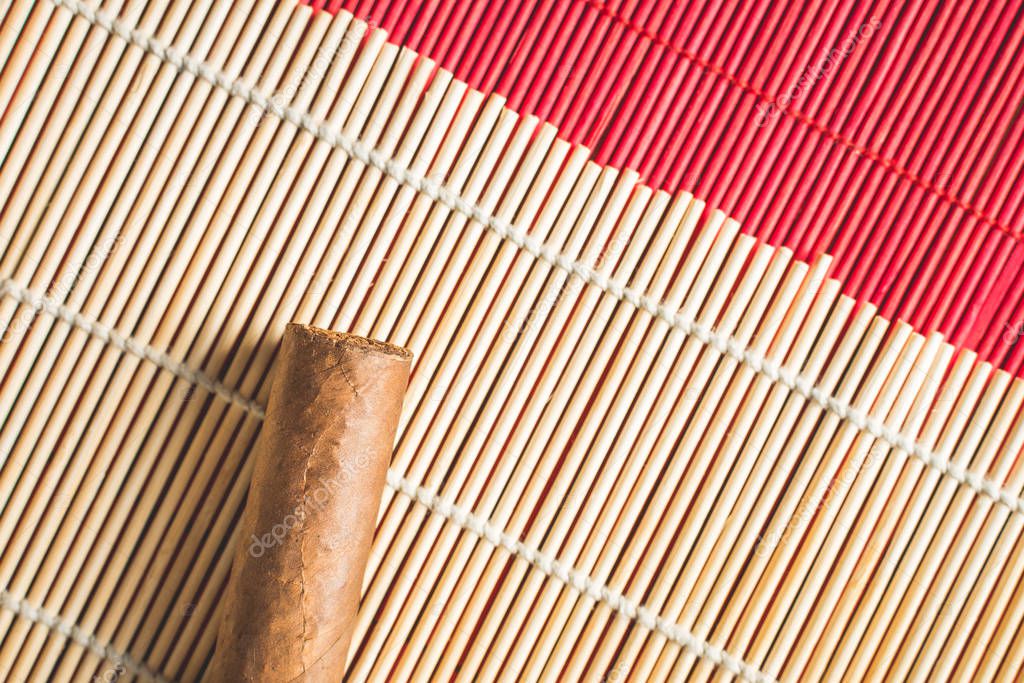 Tasty cigar on white bamboo mat