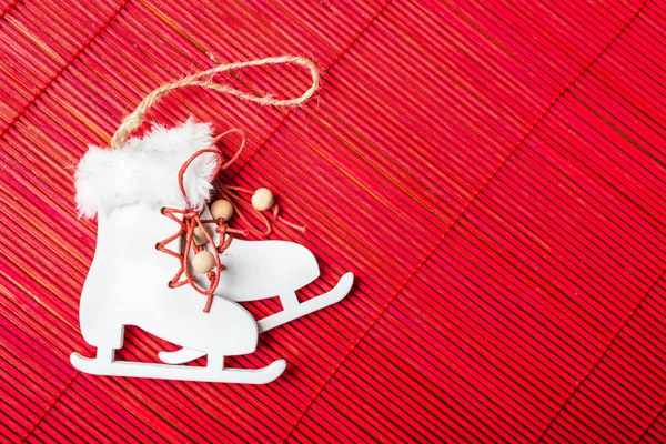Año Nuevo árbol de Navidad decoración de los patines blancos con cordones rojos en la colocación de bambú . —  Fotos de Stock