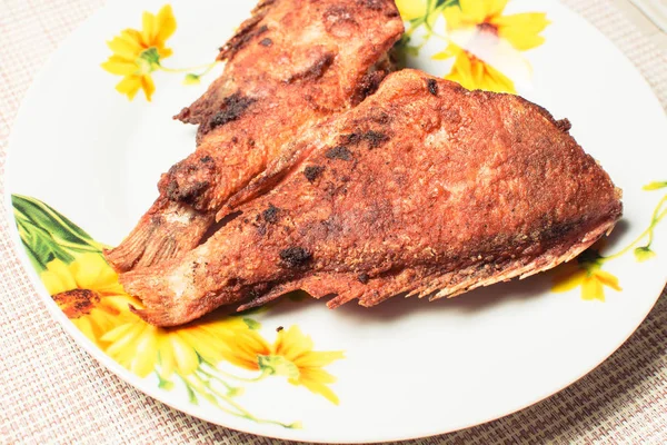 Ikan laut goreng yang dimasak di piring di atas meja dapur . — Stok Foto