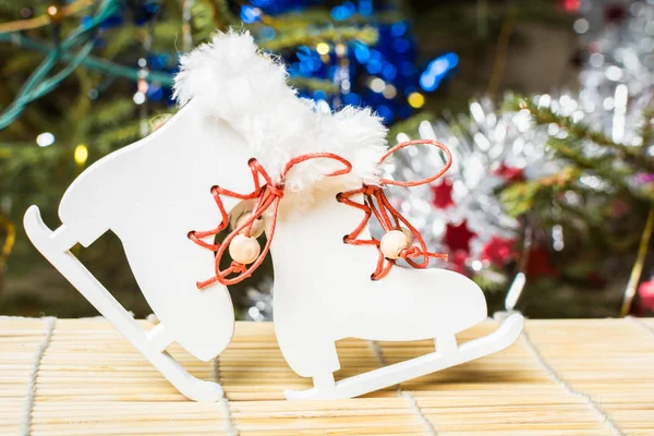 Año Nuevo árbol de Navidad decoración de los patines blancos con cordones rojos en la colocación de bambú . —  Fotos de Stock