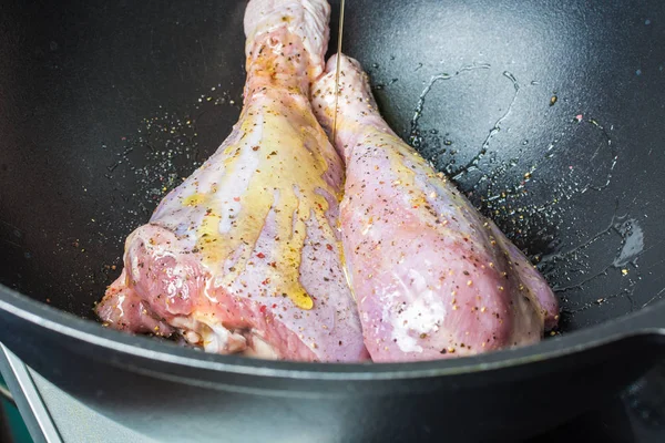 Pernas de peru cruas delicadas polvilhadas com sal e pimenta em caldeirão grande para assar no forno. — Fotografia de Stock