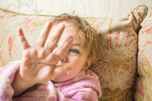 Bebê bonito com cabelo molhado após o banho em roupão mostra os dedos . — Fotografia de Stock