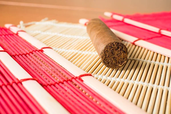 Beautiful cigar on oriental bamboo mat. — Stock Photo, Image