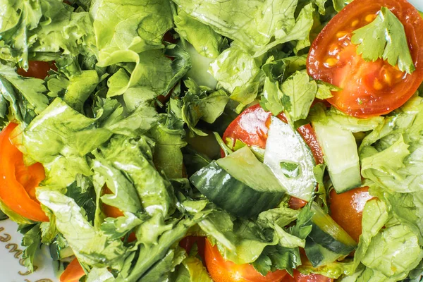 Ensalada verde fresca de tomate y pepino en plato en la mesa de la cocina . — Foto de Stock