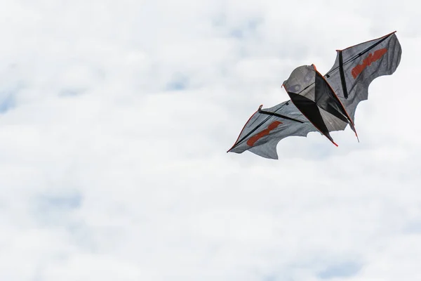 Beautiful bat shaped kite hovers in the sky. Stock Photo