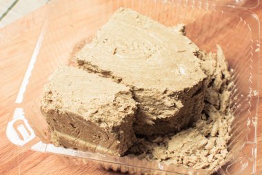 Tahtada şeffaf bir paketin içinde büyük bir parça taze halva..