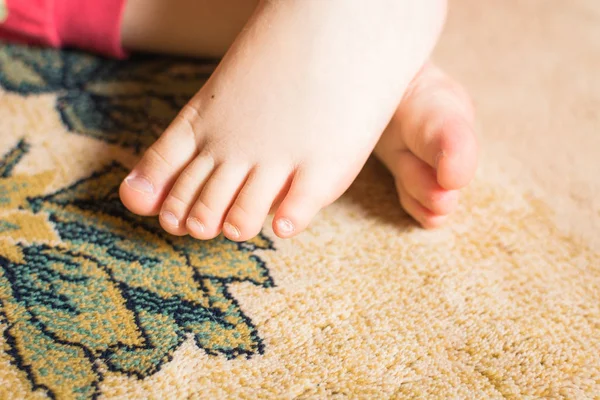 Kleine Füße eines Kindes, das auf dem Boden spielt. — Stockfoto