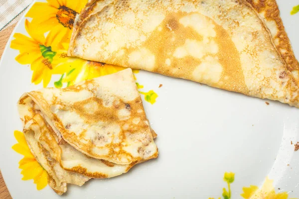 Tunna pannkakor till frukost i stor tallrik på köksbordet. — Stockfoto