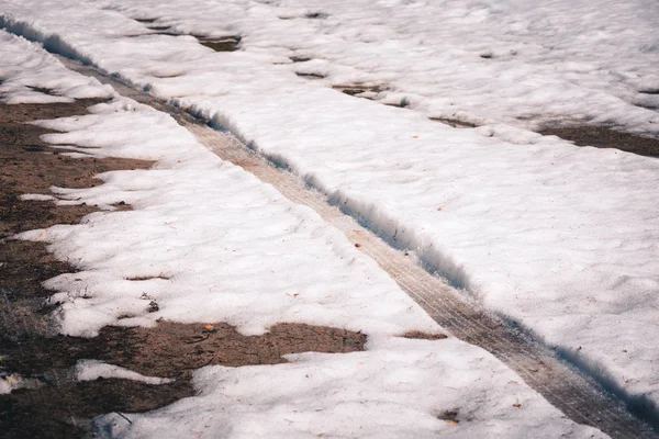 Vuile veersporen van de wielen van een Suv op witte sneeuw in het bos. — Stockfoto