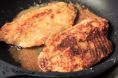 Tilapia balık fileto un ve ekmek kırıntıları tavada kızartmak için haddelenmiş.