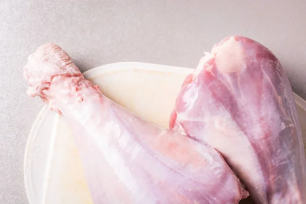Thawed raw turkey legs on white cutting board for cooking. — Stock Photo, Image