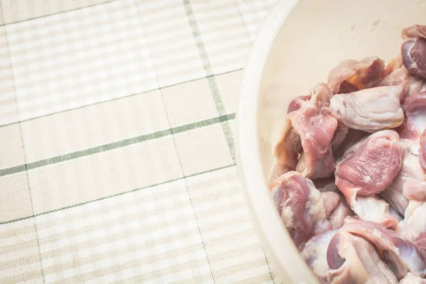 Thawed and washed chicken gizzards in eggplant on the kitchen table for cooking soup. — Stock Photo, Image