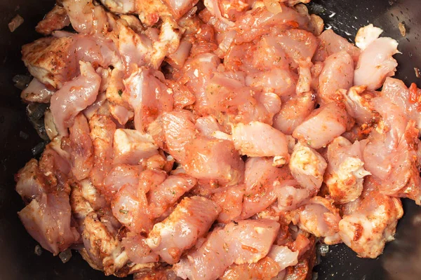 Verse stukjes rauwe kip gelegd in een traag fornuis om uit te doven. — Stockfoto