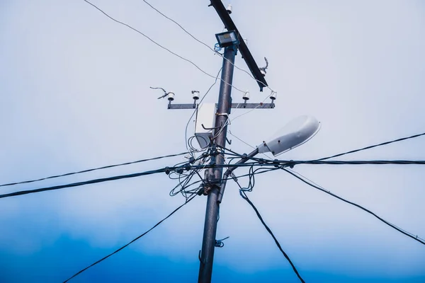 stock image Tensioned electrical wires on high pole against the blue sky