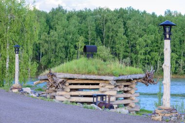 Nehir kıyısında dinlenmek için kalın kirişli bir çardak.