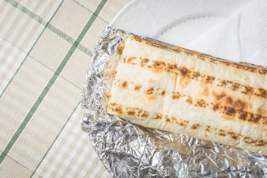 Taze et ve sebze shawarma pide ekmek sarılmış tabakta yatıyor