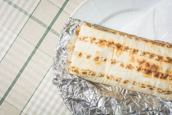 新鲜肉类和蔬菜沙瓦玛包裹在皮塔面包躺在盘子上 — 图库照片