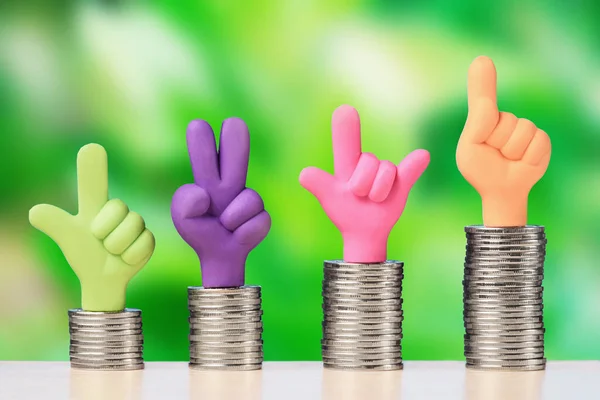 Hands with thumbs up on stack of coins. The concept of investment growth and finance
