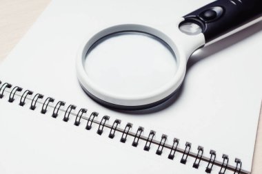 Açık bir defterde araştırma yapmak için büyüteç. İş planı analiz kavramı