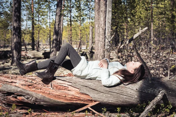 疲れて女の子でライトジャケット後ハイキング睡眠とともに彼女の目を閉じて上の倒木で松の森 — ストック写真