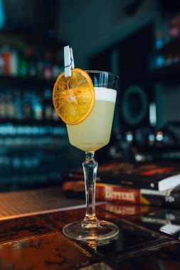Barda ya da restoran arka planında kurutulmuş portakal dilimli Pisco Sour kokteyli. Yakın çekim..