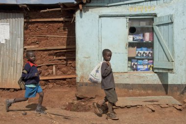 Kibera, Nairobi, Kenya bir sokakta vitrin prezervatif ile kiosk tarafından erkek geçmek.