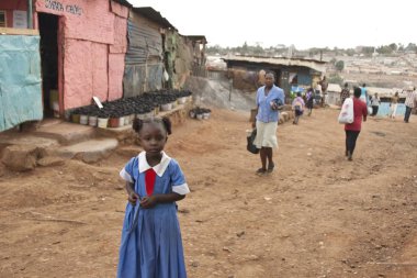 Liseli kız evine Kibera, Nairobi, Kenya bir sokak.
